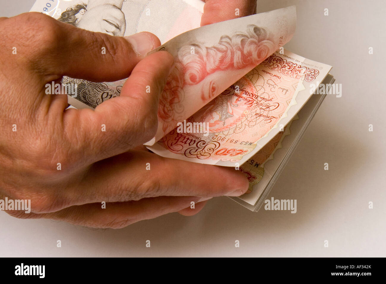 A man counting five thousand pounds in cash new fifty pound notes 5000