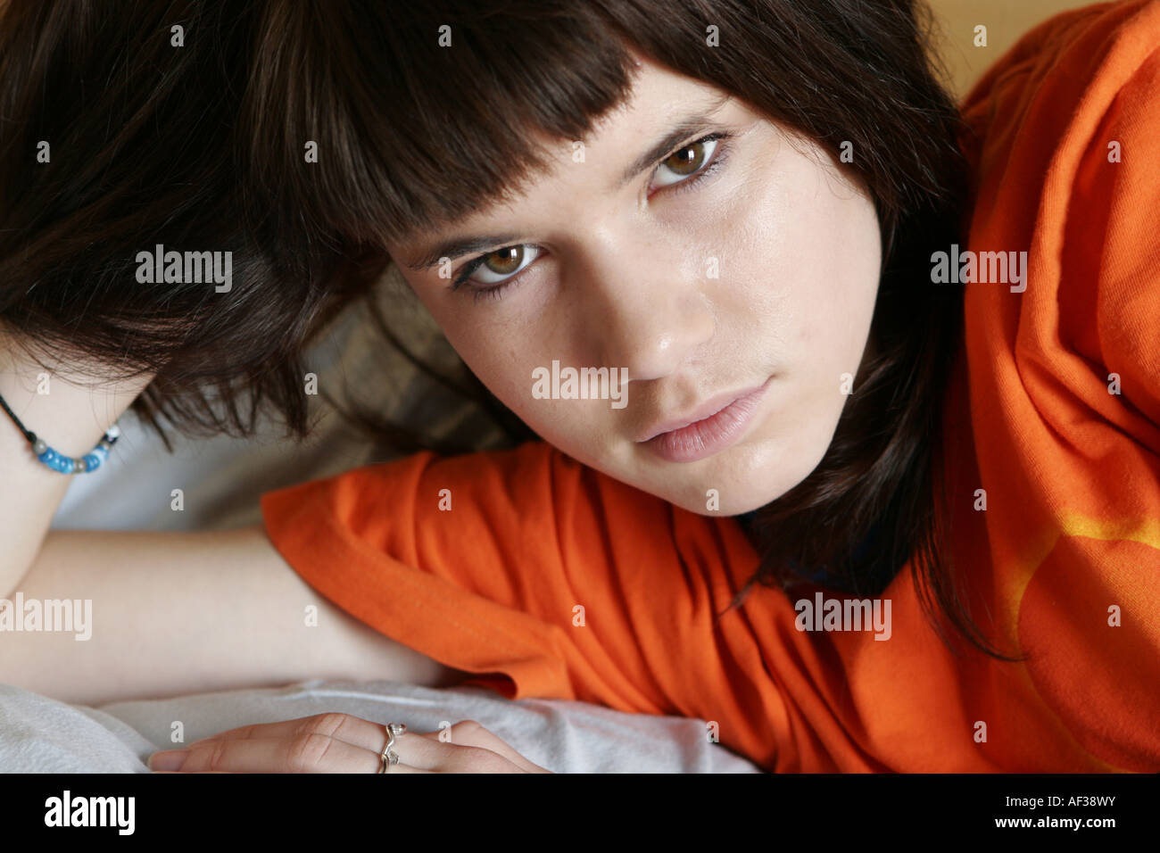 Sad teenager girl lying on the bed Stock Photo