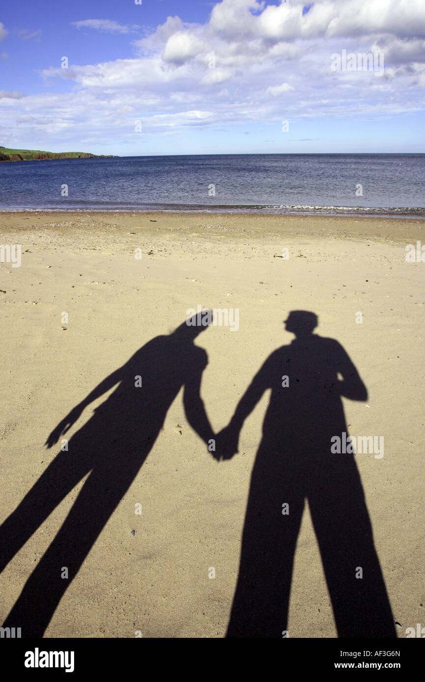 shadows of couple hand in hand on a beach Stock Photo - Alamy