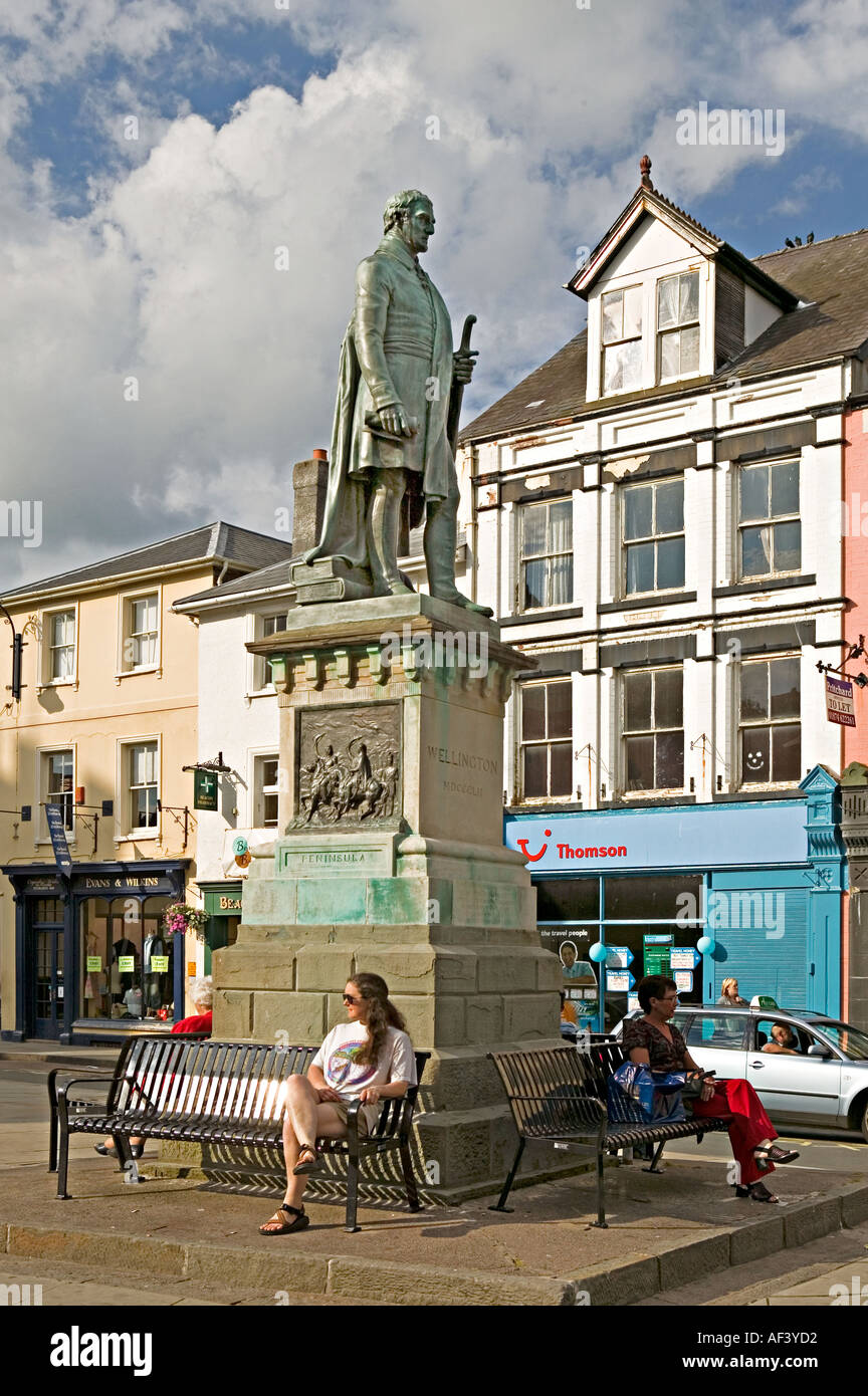 Female tourist sitting beneath Wellington statue Brecon centre Wales UK