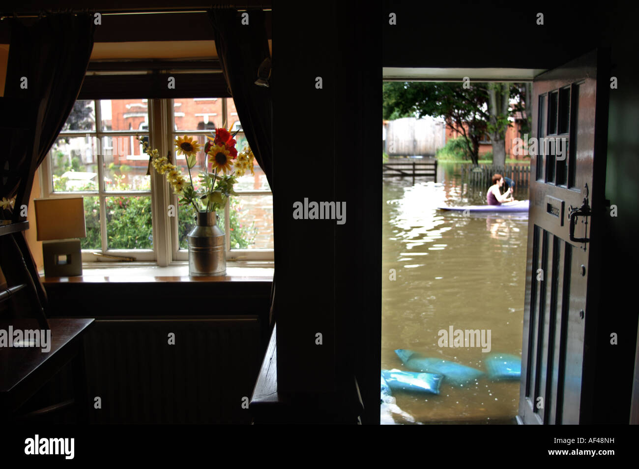 A canoeist passes the flooded Queens Head pub in Longford Gloucester England July 2007 Stock