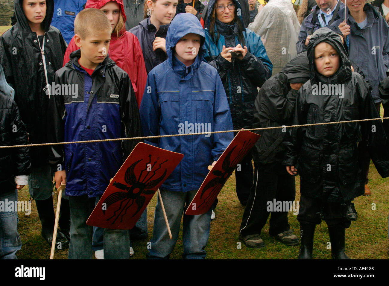 An audience at a Roman re enactment event wait for performers in the rain Stock Photo