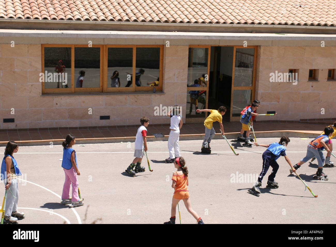 Spanish children are playing inline hockey in the old town of Alcudia Mallorca Spain Stock Photo