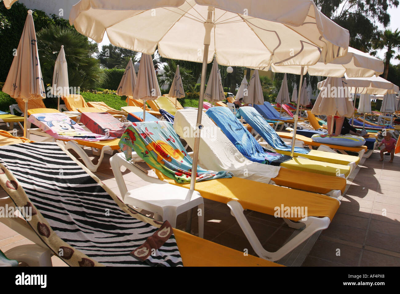 Even though signs says otherwise people still occupy the sunbeds with their towels so nobody else can use them. Mallorca, Spain Stock Photo