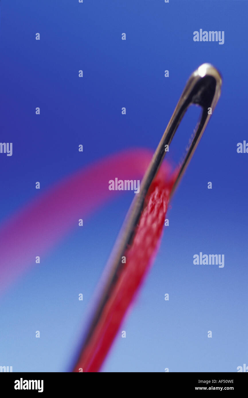 Close-up of a thread in the eye of a needle Stock Photo - Alamy