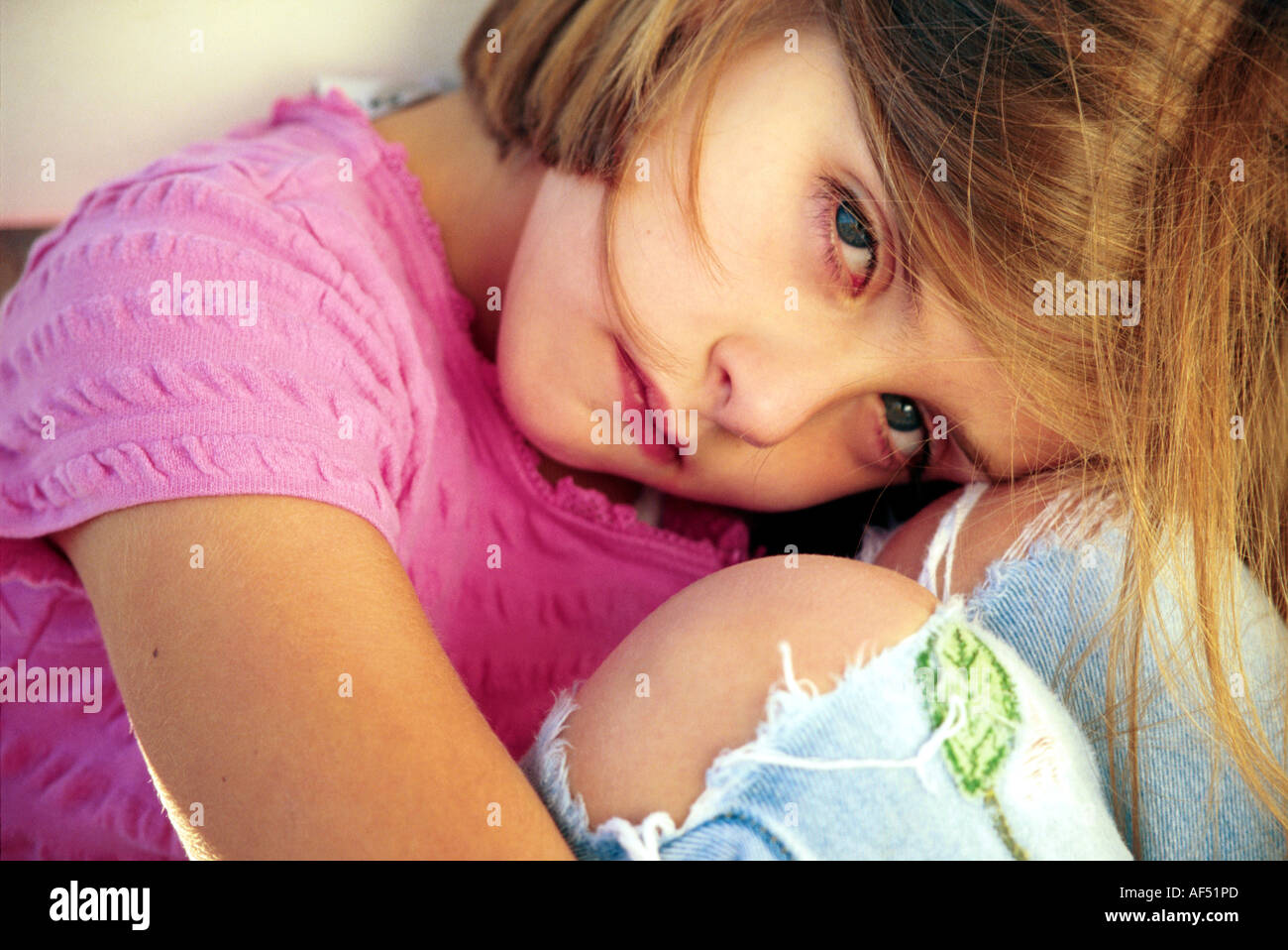 Portrait of a girl hugging her knees Stock Photo - Alamy