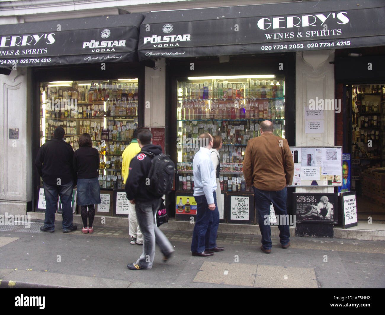 People looking at the window display Gerry's off licence Old Compton Street Soho London Stock Photo