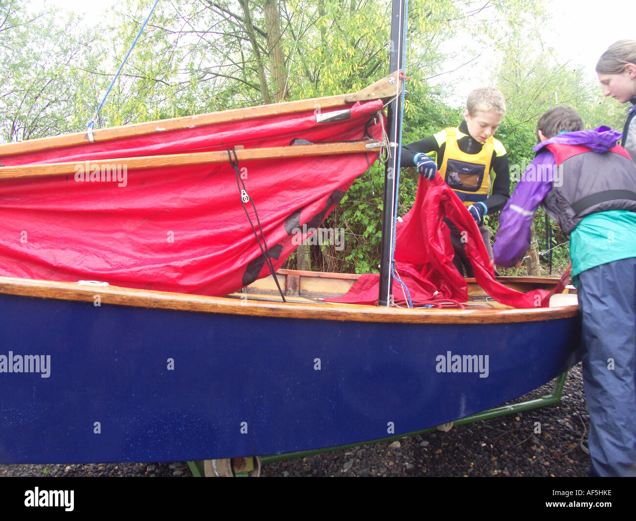 Two children boy and girl preparing their mirror sailing boat Stock Photo