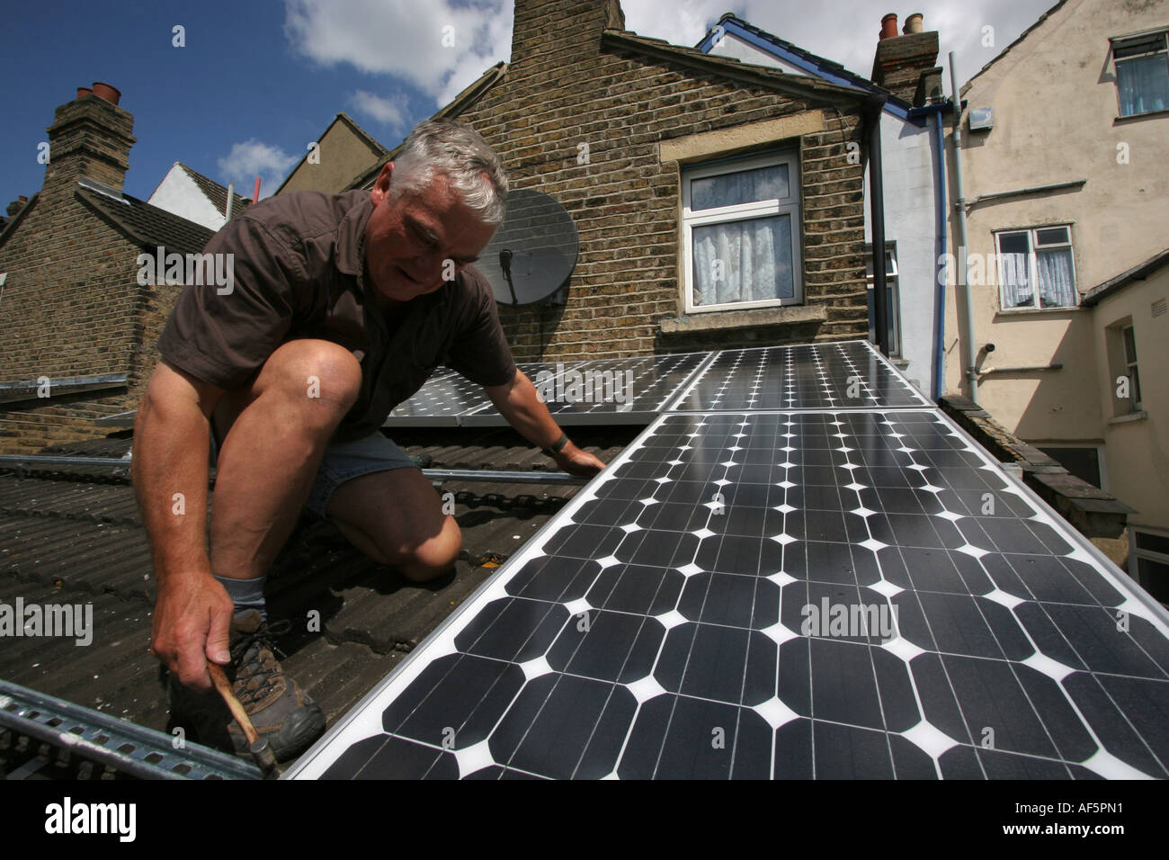 Solar panels being installed on the roof of a house in South East London. Stock Photo