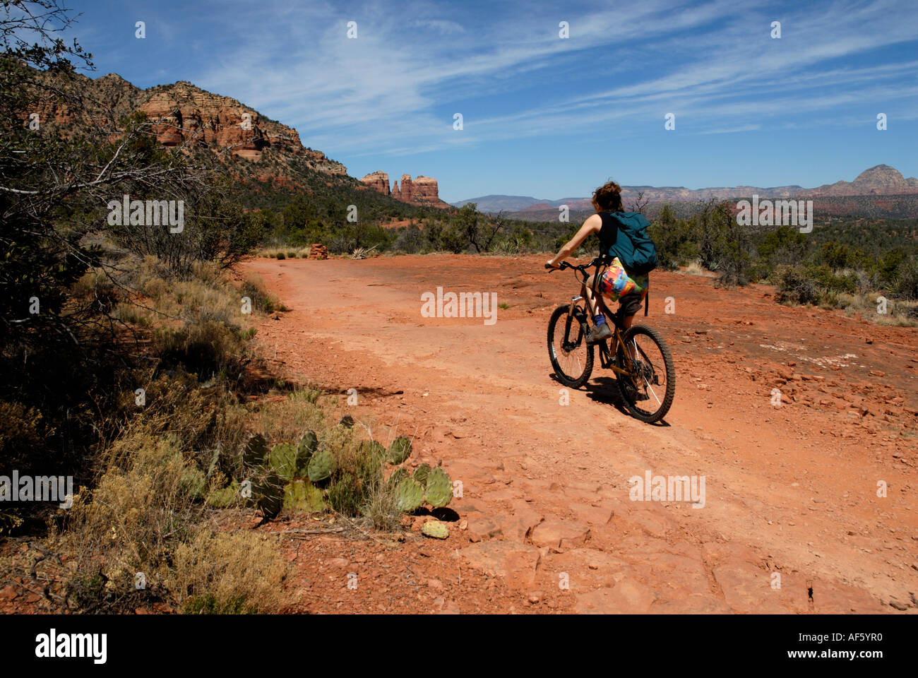 Woman riding mountain bike on trail path in Red Rock Country, near Sedona, Arizona Stock Photo