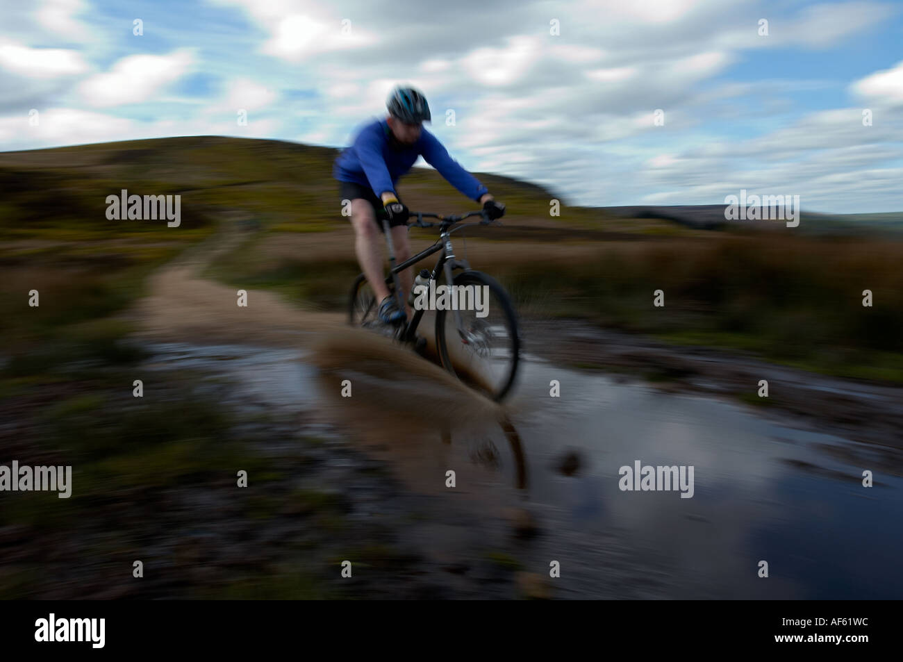 mountain bike rider races through puddle on baildon moor yorkshire ...