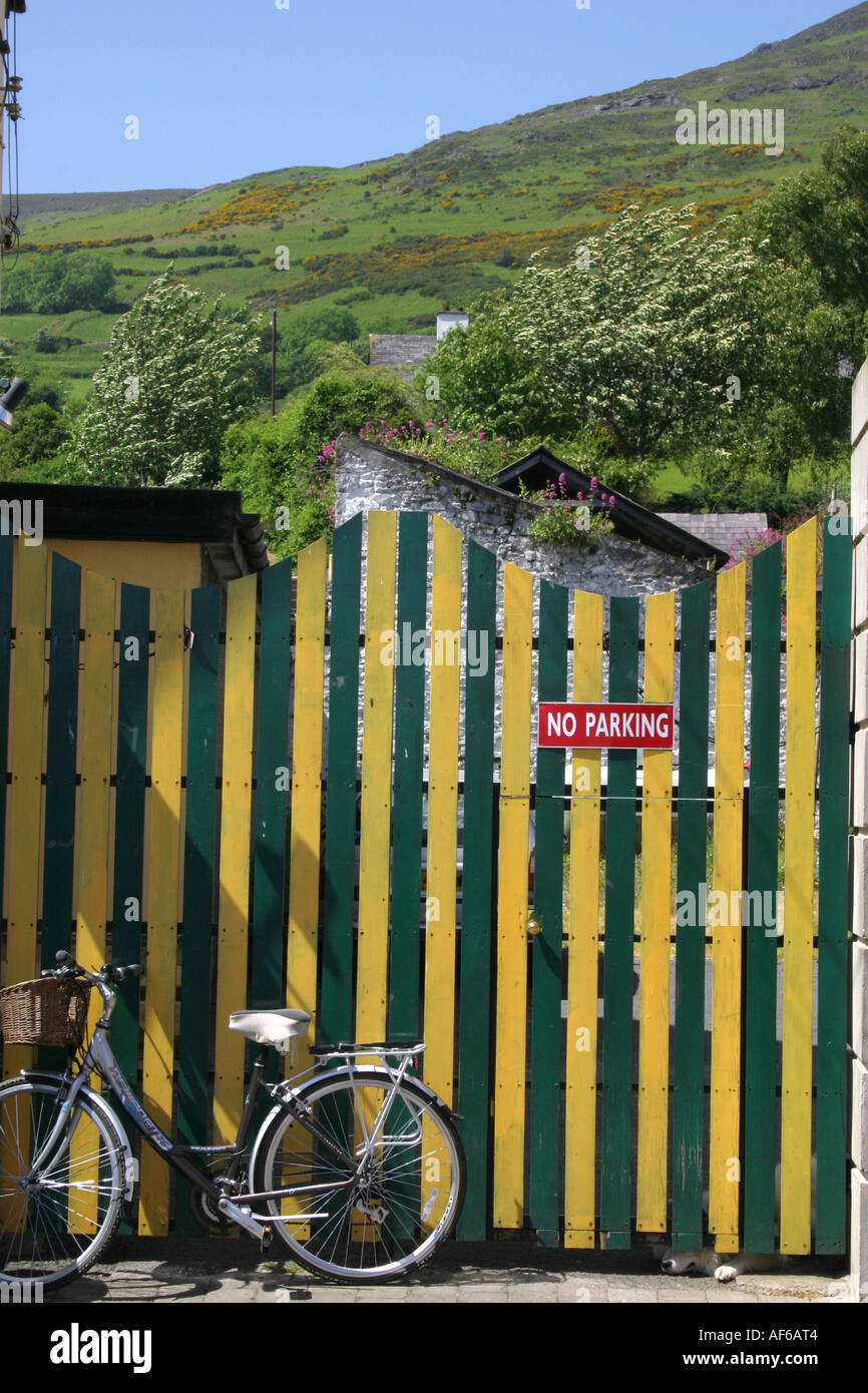 Ladies bicycle propped against a brightly coloured gate in Carlingford, County Louth, Ireland -Cooley Mountains in the backgroun Stock Photo