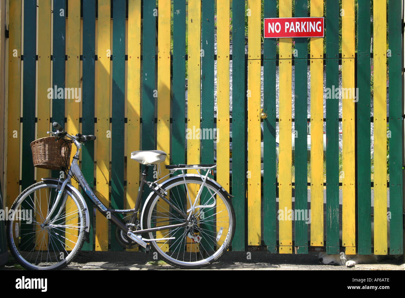 Ladies bicycle propped against a brightly coloured gate in Carlingford, County Louth, Ireland Stock Photo