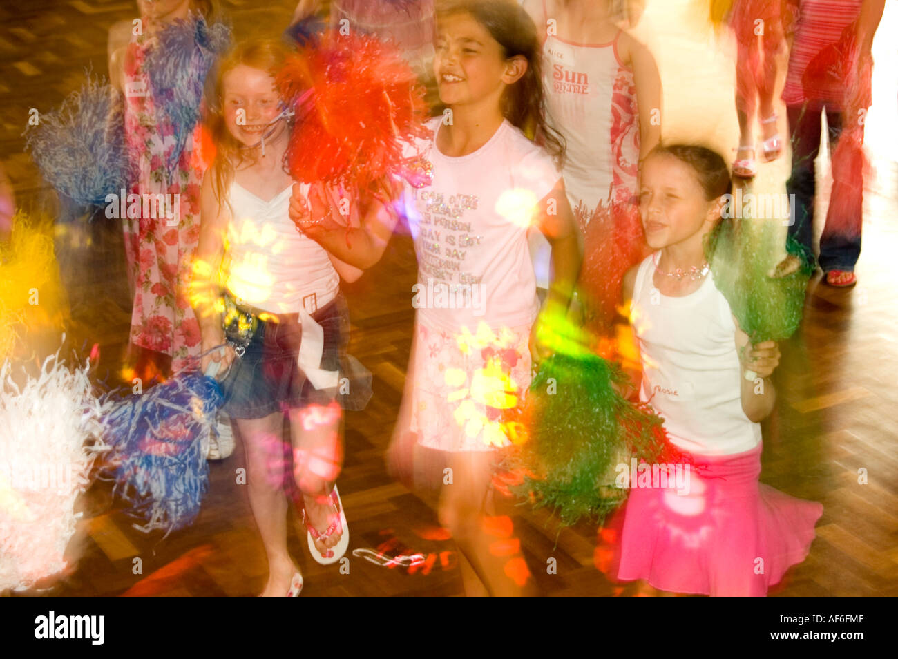 Vælg I fare status Horizontal close up of girls shaking paper pom-poms in time to the music at  a ninth birthday party Stock Photo - Alamy