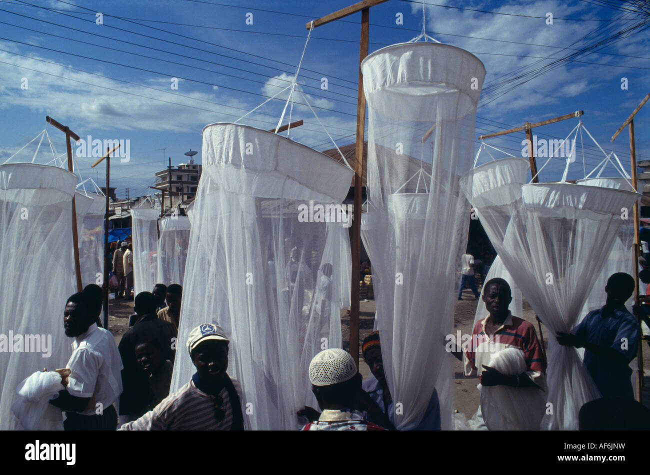 TANZANIA East Africa Dar es Salaam Mosquito nets for sale at market with men in the foreground Stock Photo