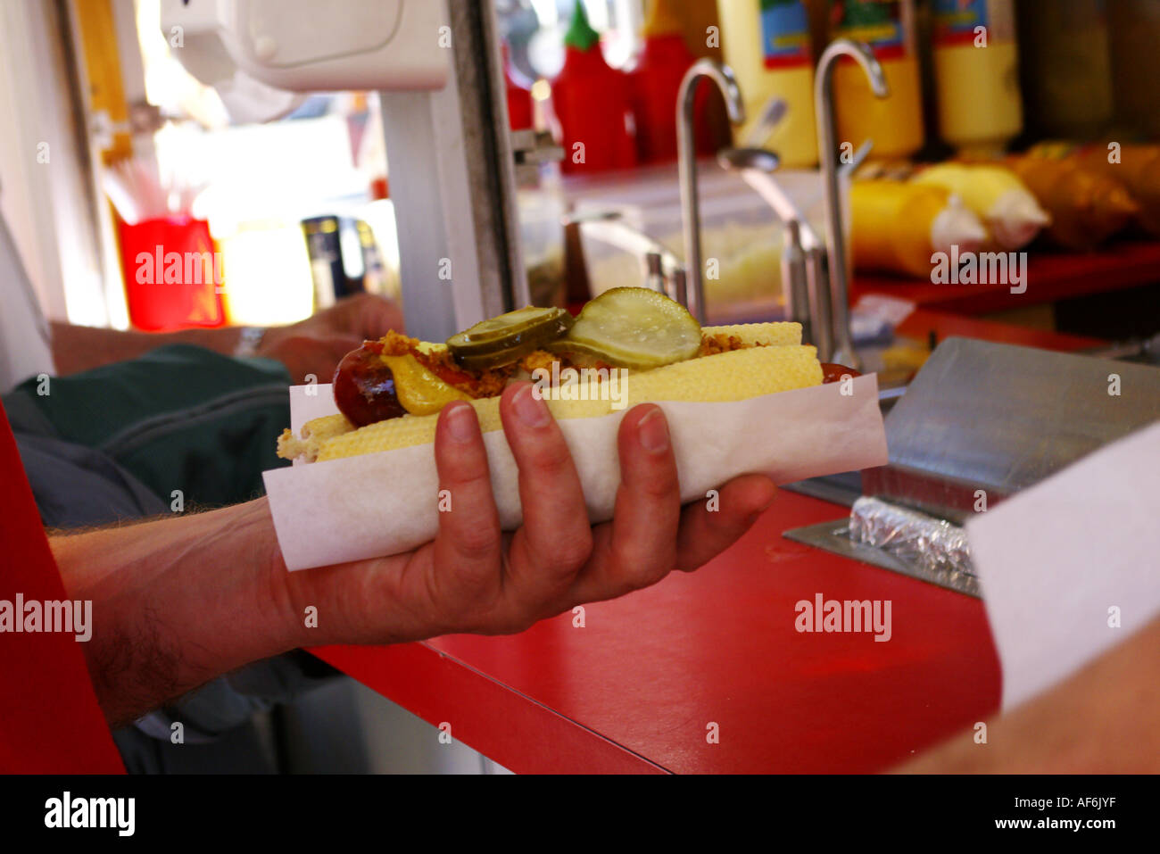 A tourist is buying a Danish hot dog in the town square in Copenhagen in Denmark Stock Photo
