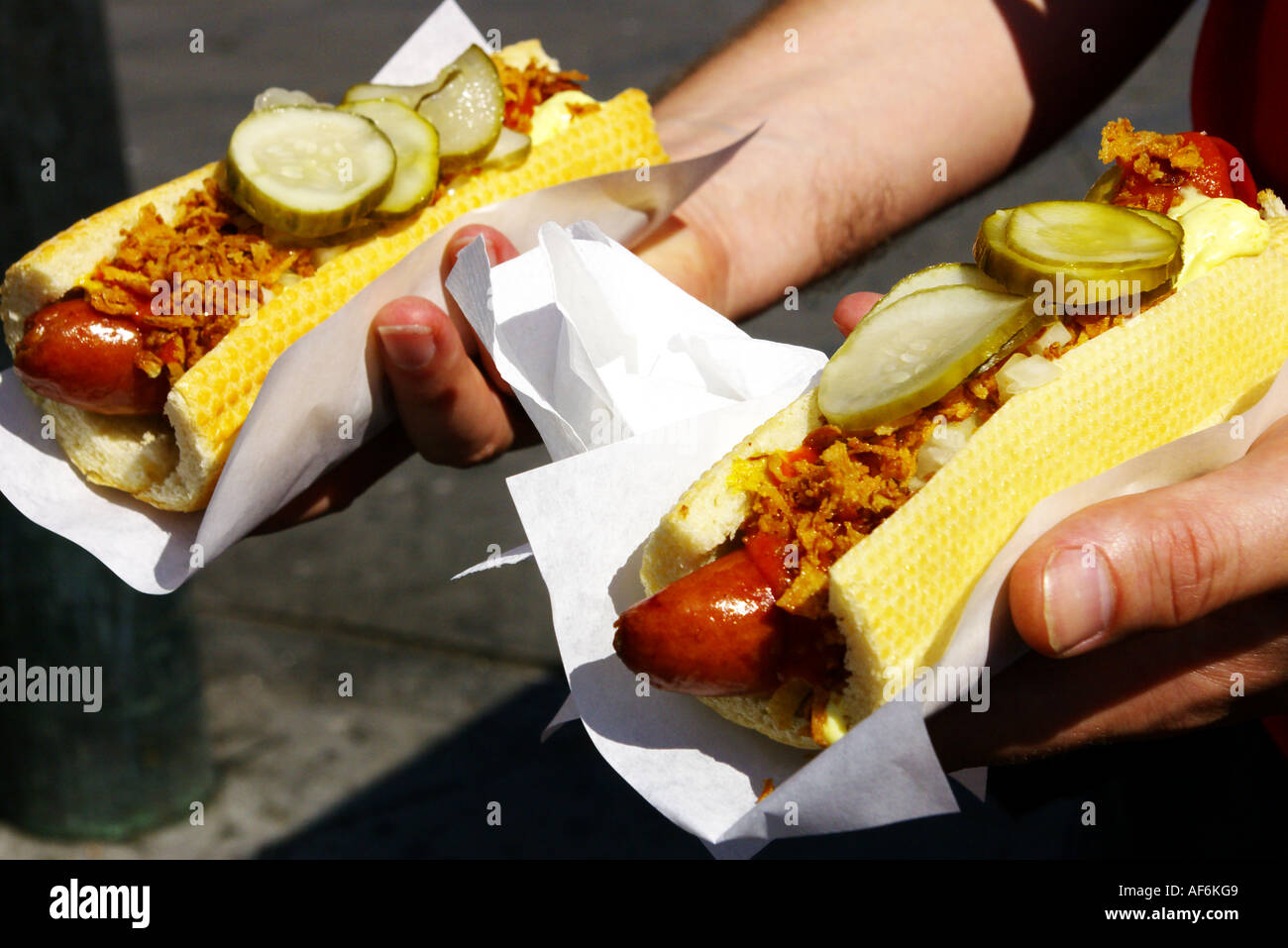 A tourist is buying Danish hot dogs in the town square in Copenhagen in Denmark Stock Photo