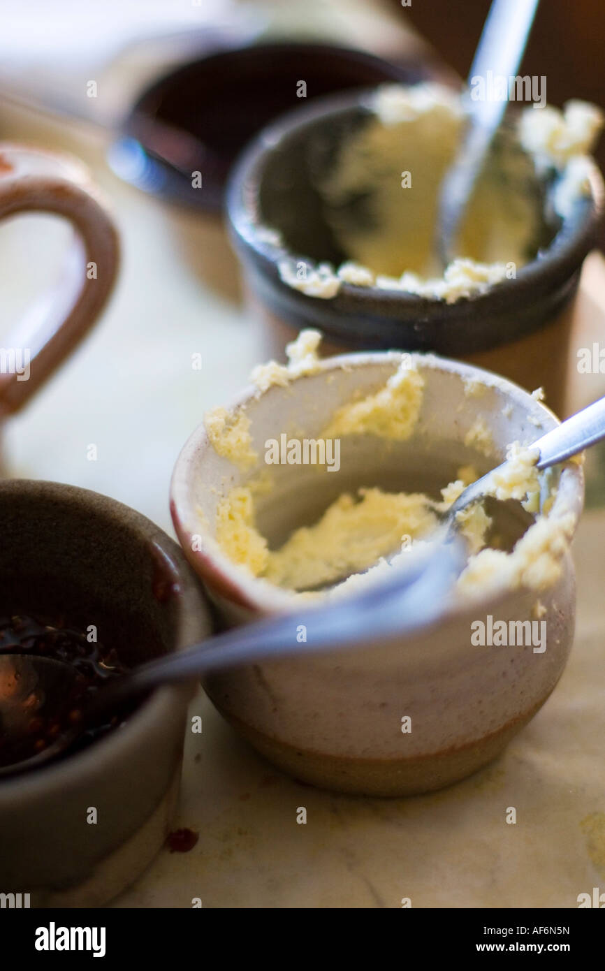 Small ceramic pots containing clotted cream and jam as part of a cream tea Stock Photo Alamy