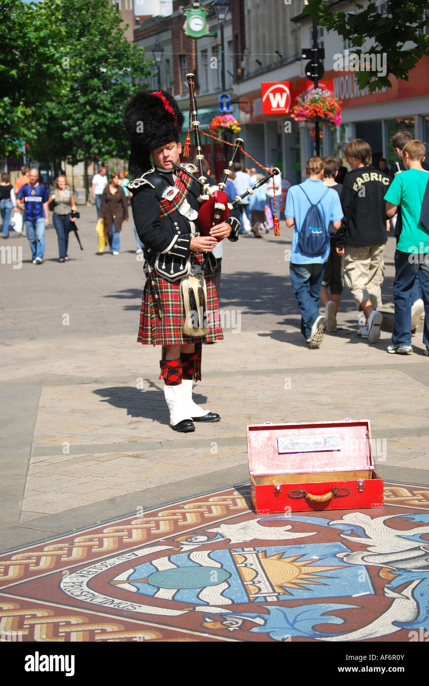 Scottish bagpipe player playing in High Street, Staines-upon-Thames, Middlesex, England, United Kingdom Stock Photo