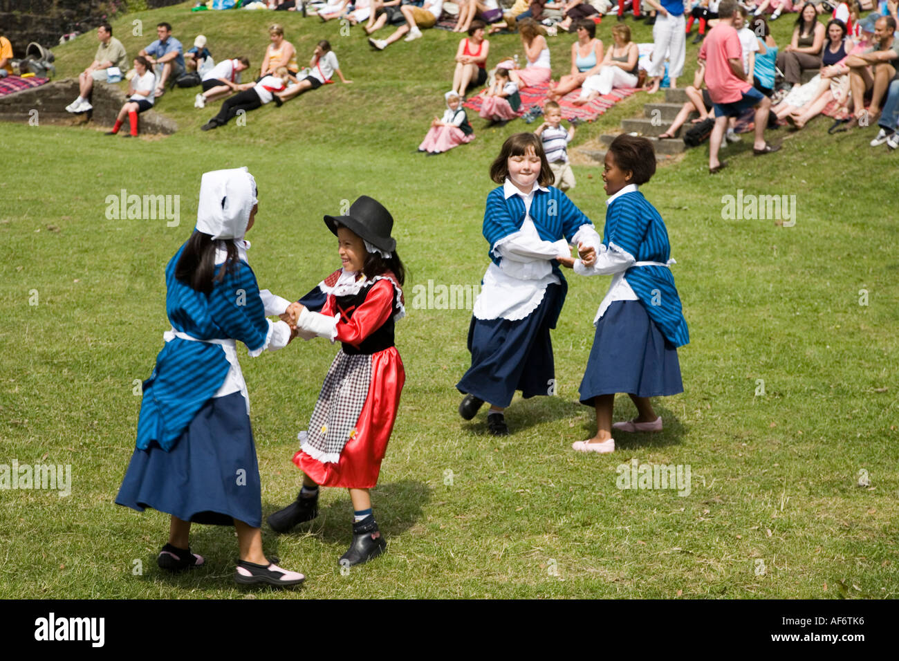 Children in traditional costume country dancing at a festival in a ruined castle grounds Abergavenny Wales UK Stock Photo