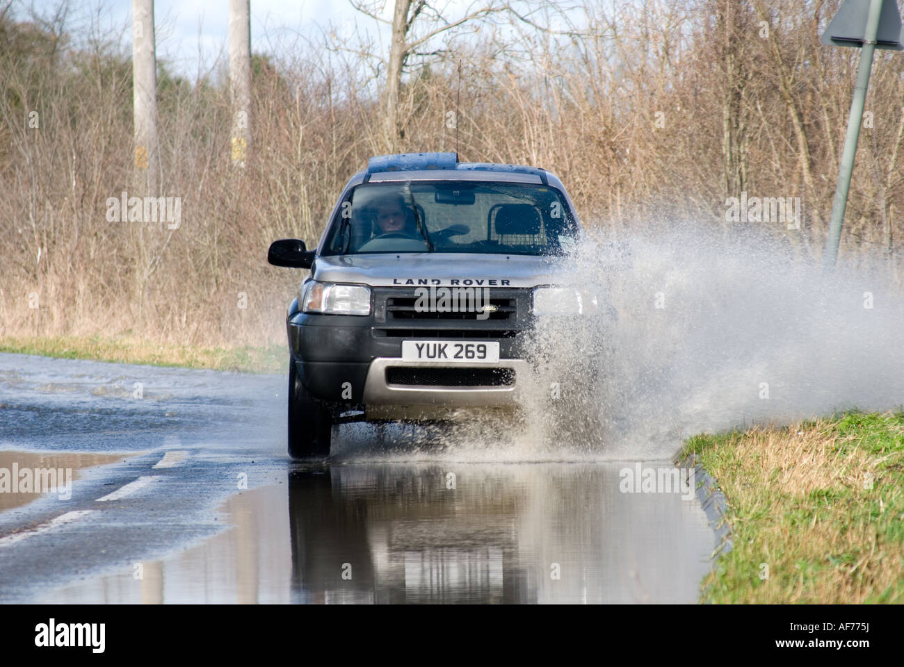 land rover freelander car driving along a flooded road in rural england Stock Photo