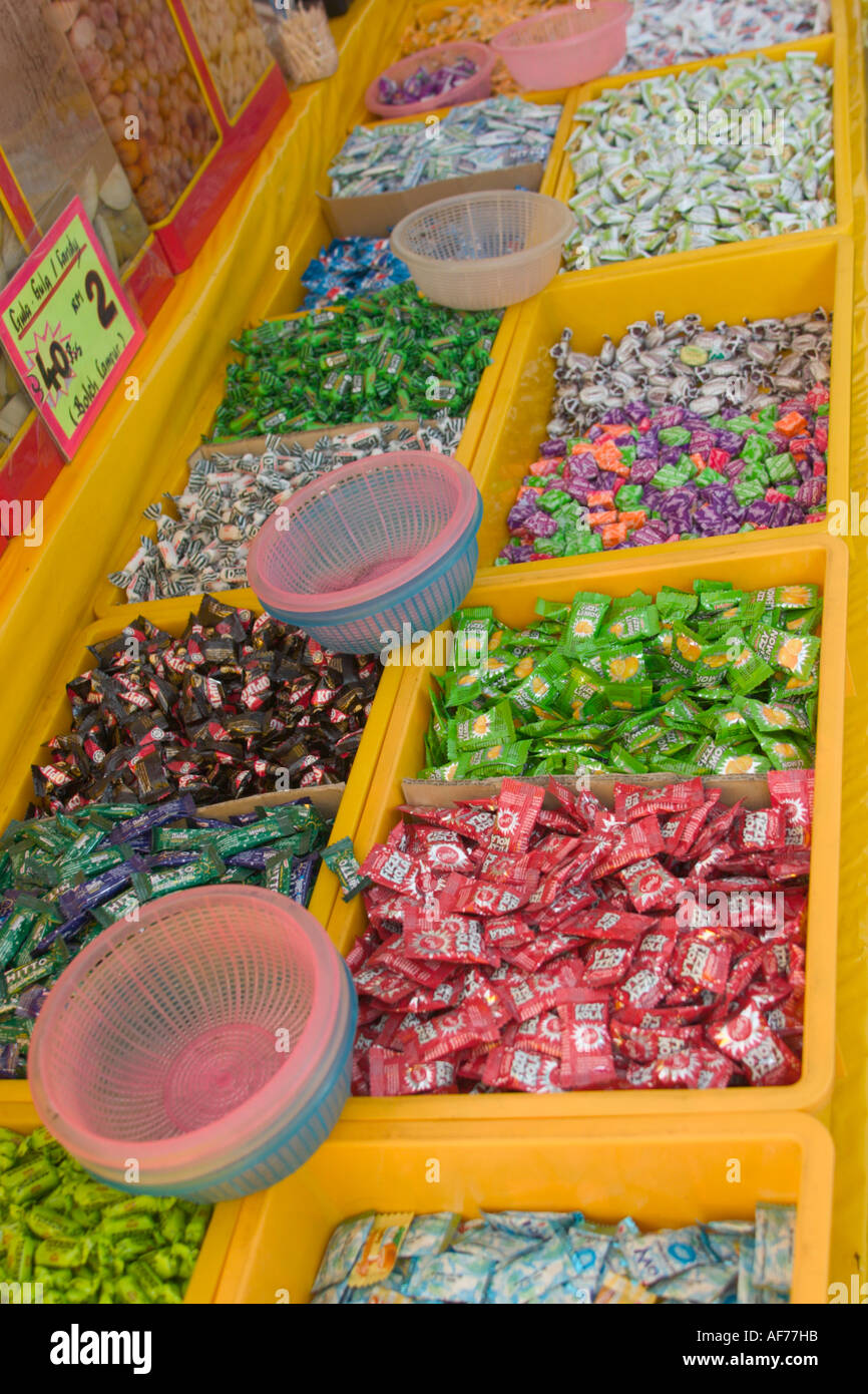 trays of colourful sweets and candies being sold at a bazaar stall in