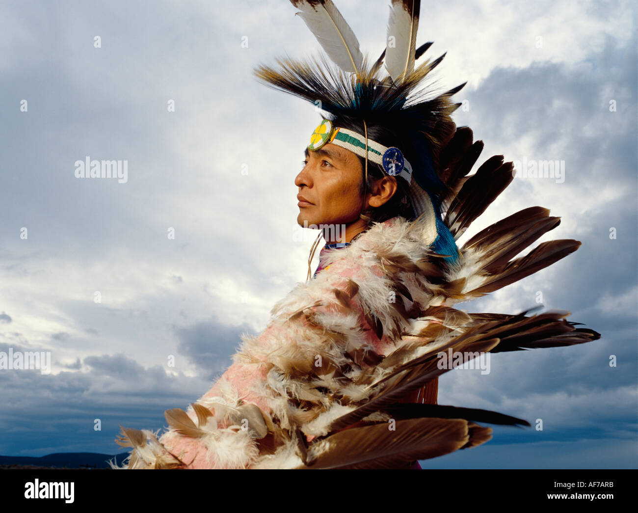 Native American man in traqditional feather headdress. Outdoor portrait profile. Stock Photo