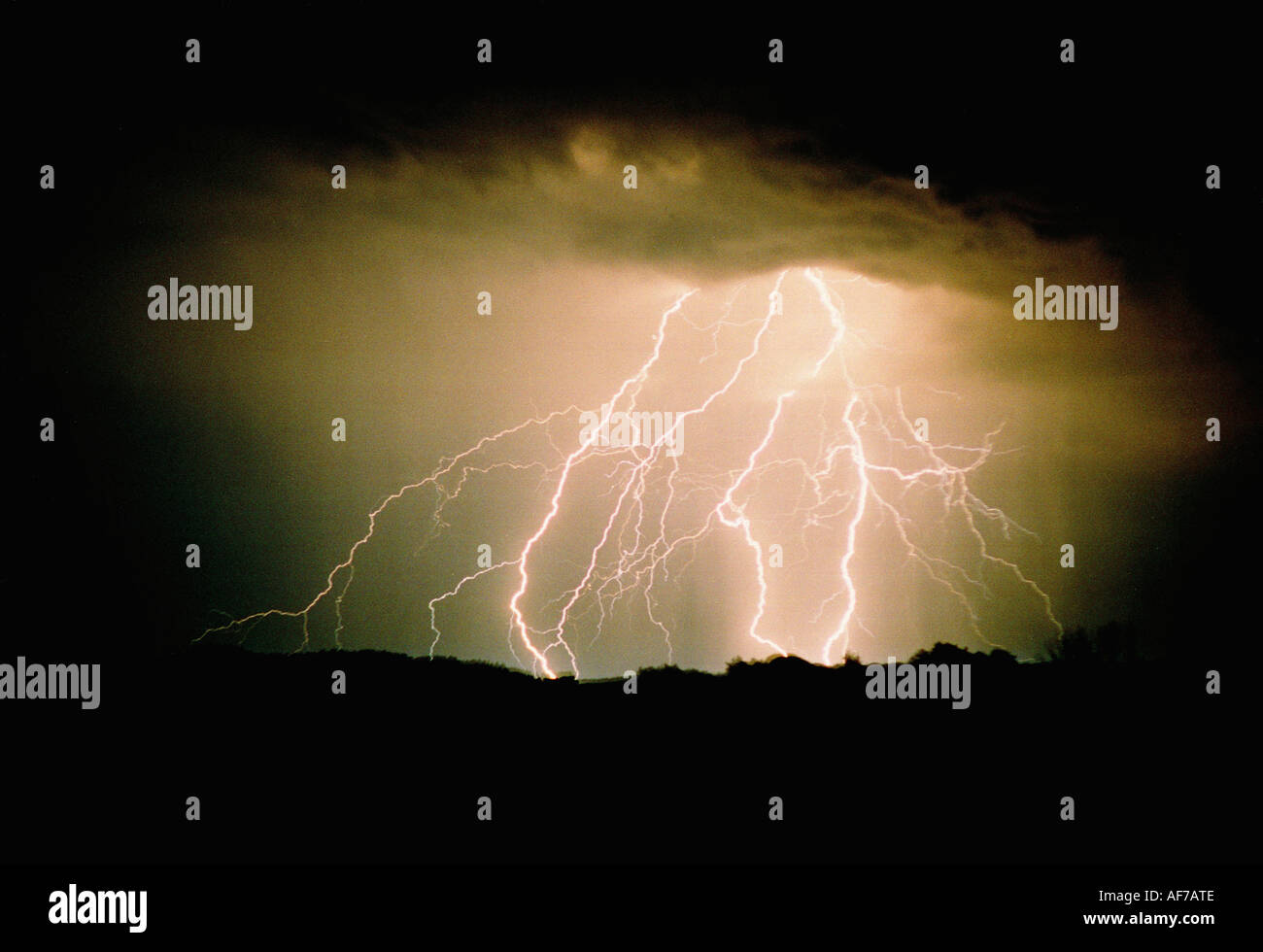 Forked lightning striking over ridge of hill Stock Photo Alamy