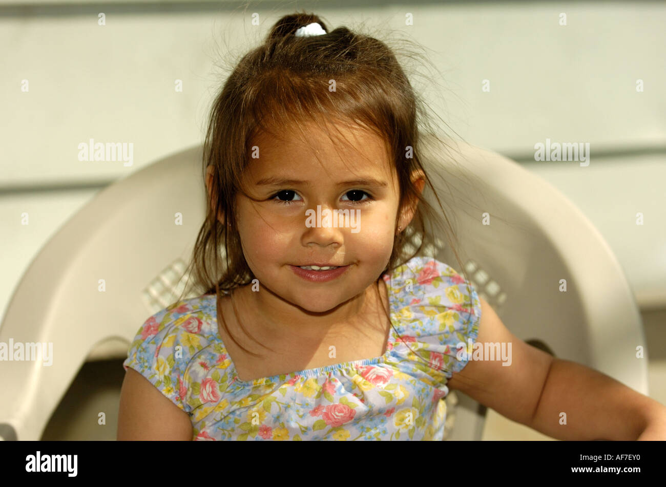 Smiling girl sitting in chair Stock Photo - Alamy