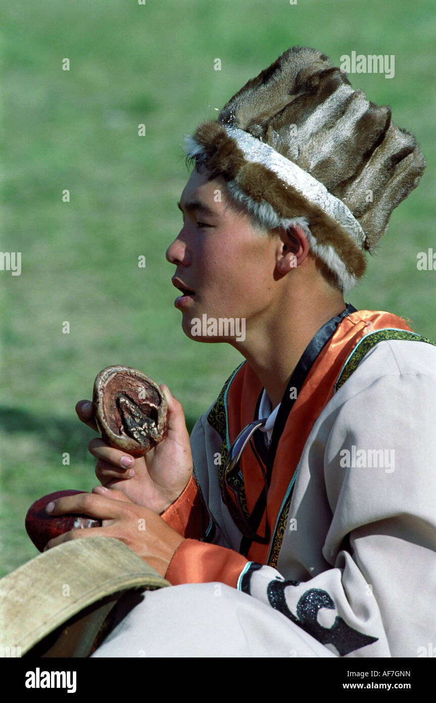 Portrait of a boy performing national Altaic epics and accompanied by the traditional music instrument – horse hoofs. Russia Stock Photo