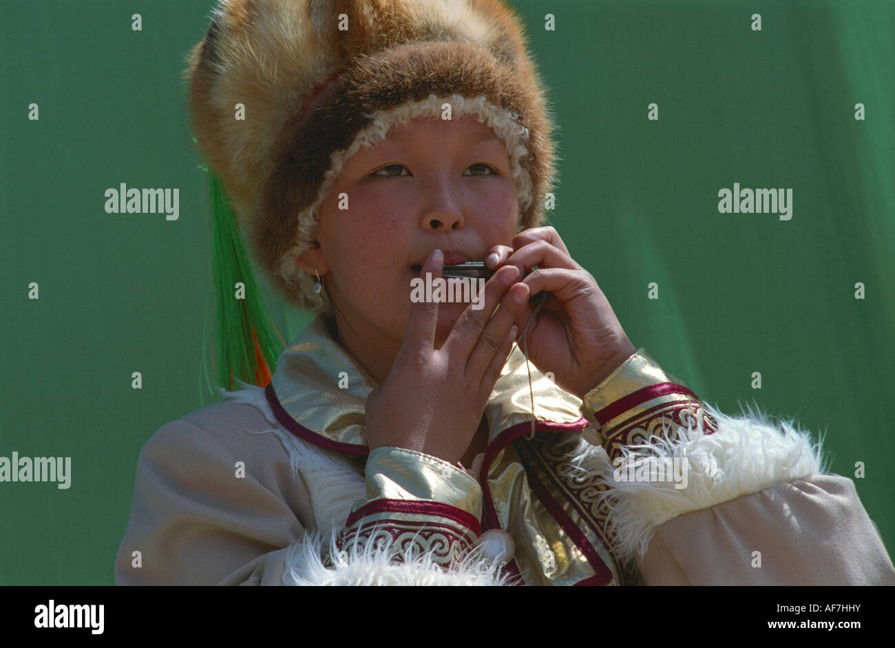 Portrait of a young girl playing national Altaic instrument komus. El-Oiyn - national festival of Altaic people. Russia Stock Photo