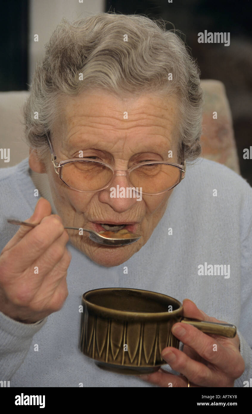 elderly woman enjoying a winter cup of vegetable soup Stock Photo Alamy