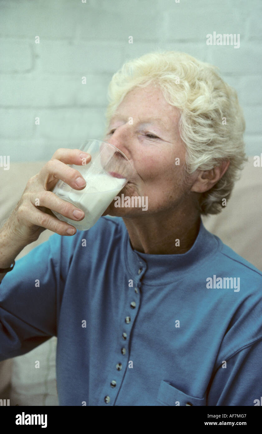 elderly woman drinking a glass of milk a good source of calcium to help