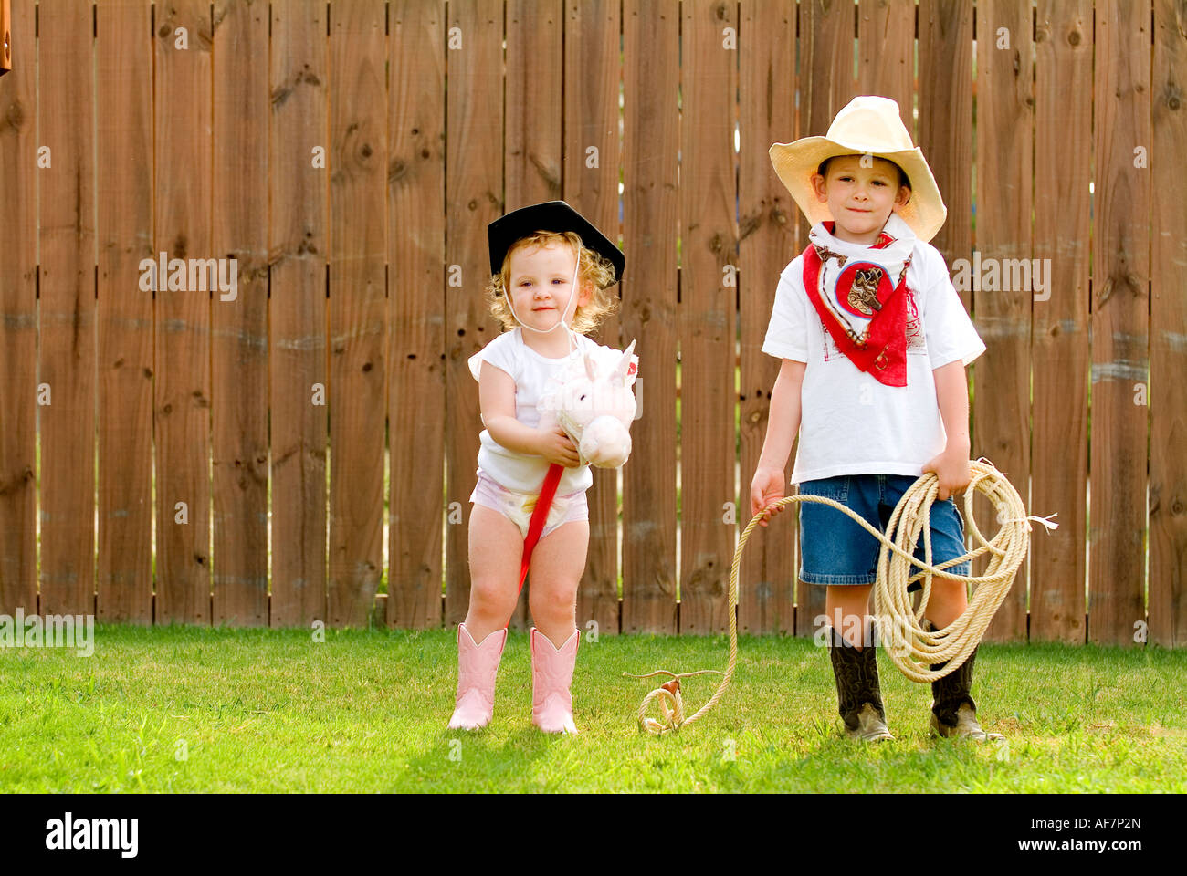 5 year old  2 year old in the backyard dressed up like pseudo cowfolks Stock Photo