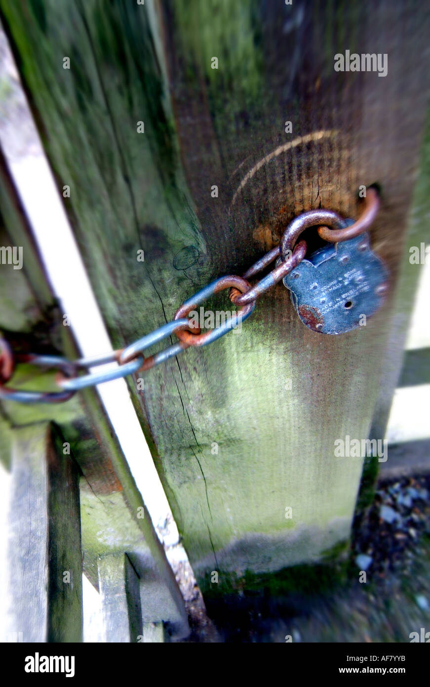 vertical portrait format picture of locked farm gate with chain and padlock Stock Photo