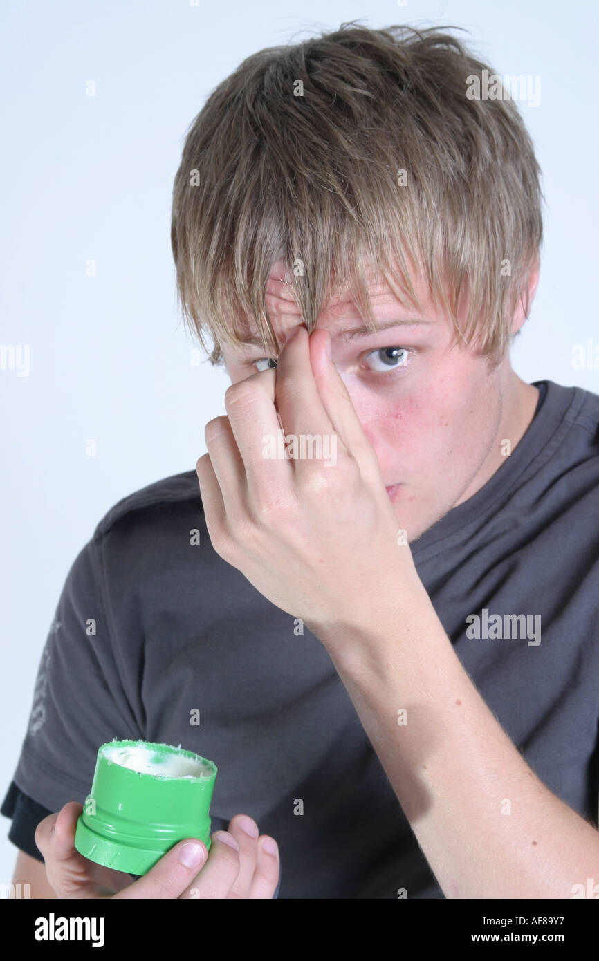 A Stock Photograph of a Young Adult using Wax to Style his Hair Stock