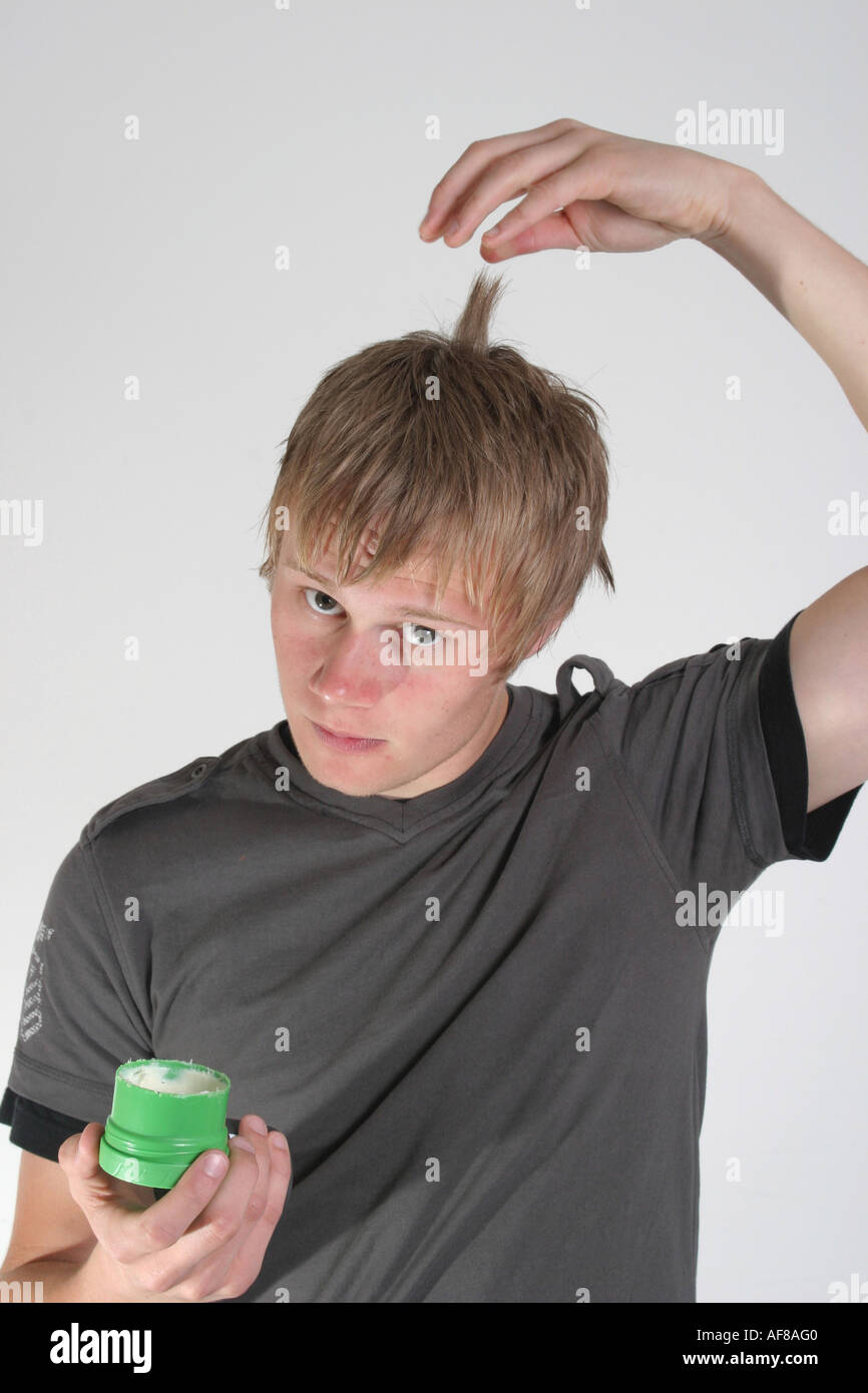 A Stock Photograph Of A Young Adult Using Wax To Style His Hair