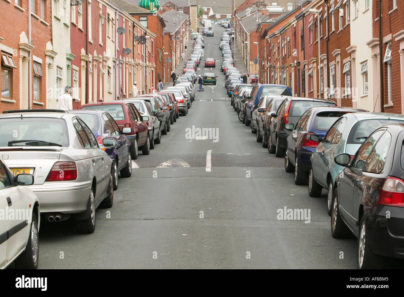 an overcrowded muslim area of blackburn, Lancashire, UK, with cars parked all along the street Stock Photo