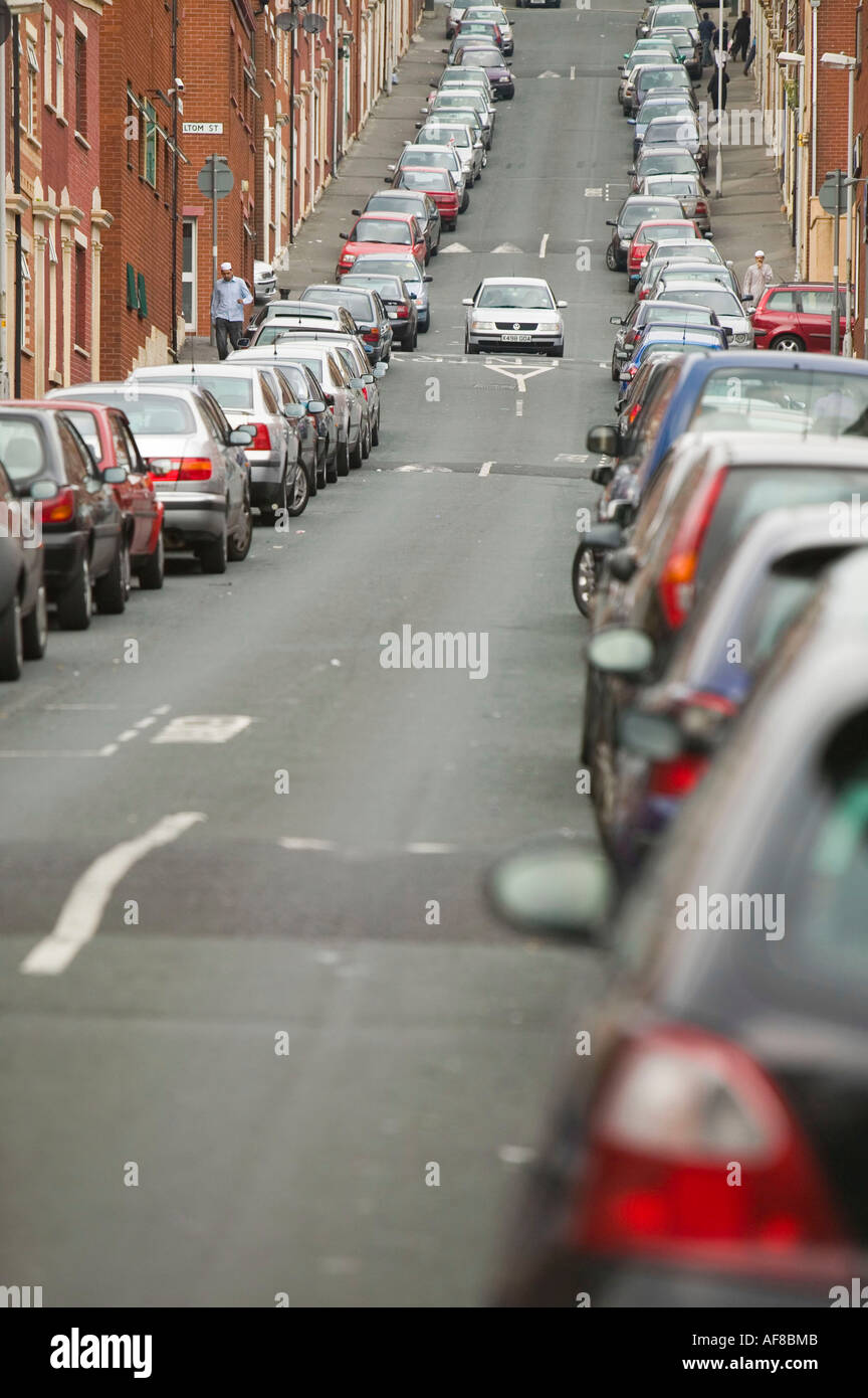 an overcrowded muslim area of blackburn, Lancashire, UK, with cars parked all along the street Stock Photo