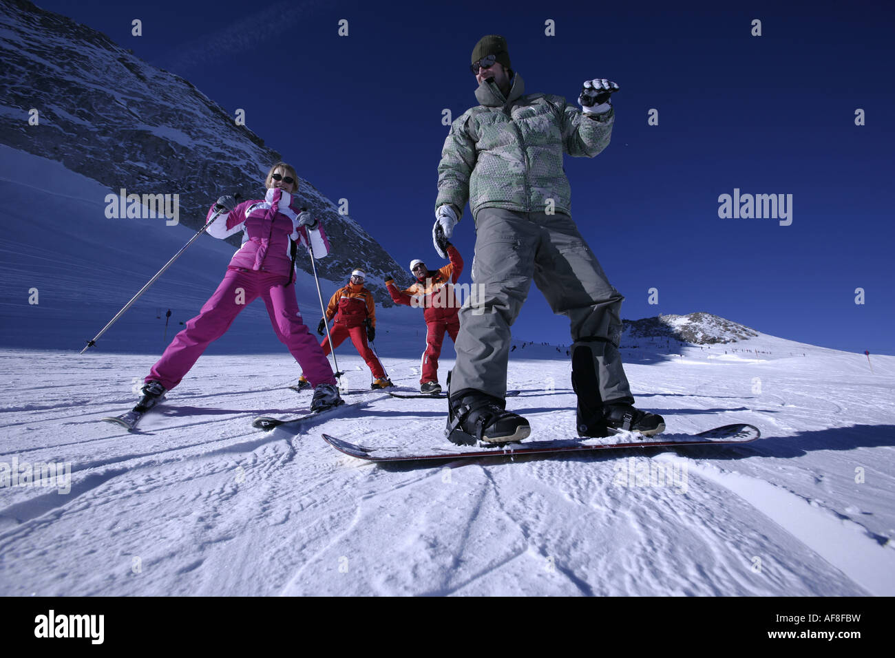 Two people having ski and snowboard lessons with ski instructors, Hintertux Glacier, Tyrol, Austria Stock Photo