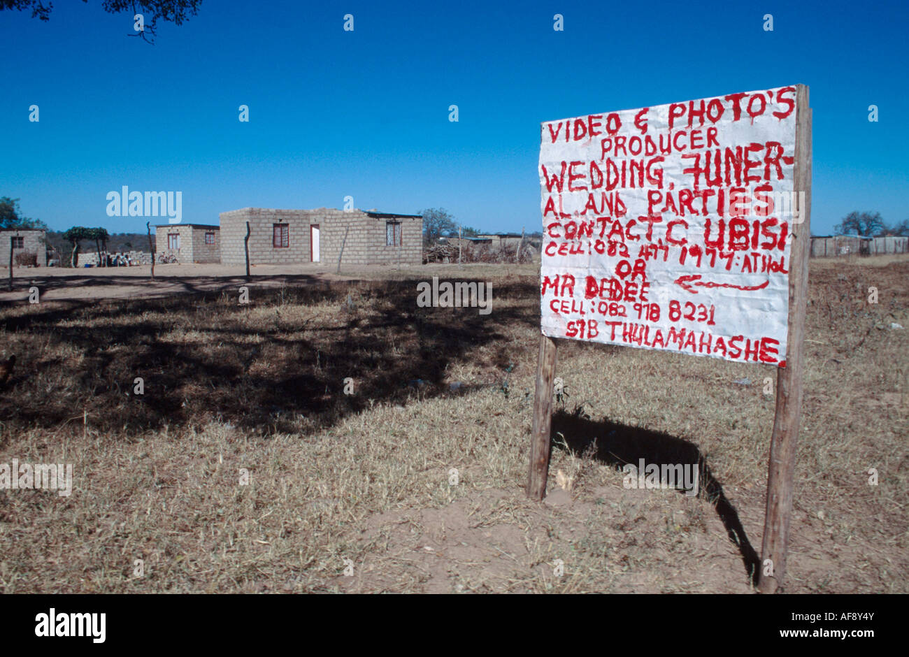 A signpost in rural Africa advertising a small business which does videos and photography at weddings and funerals Stock Photo