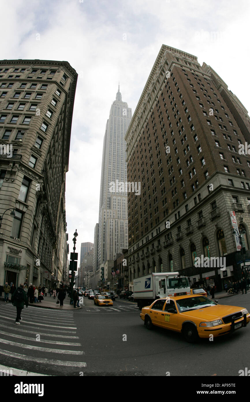 fisheye shot of yellow cab and empire state building at intersection of 34th street broadway and 6th avenue at herald square Stock Photo