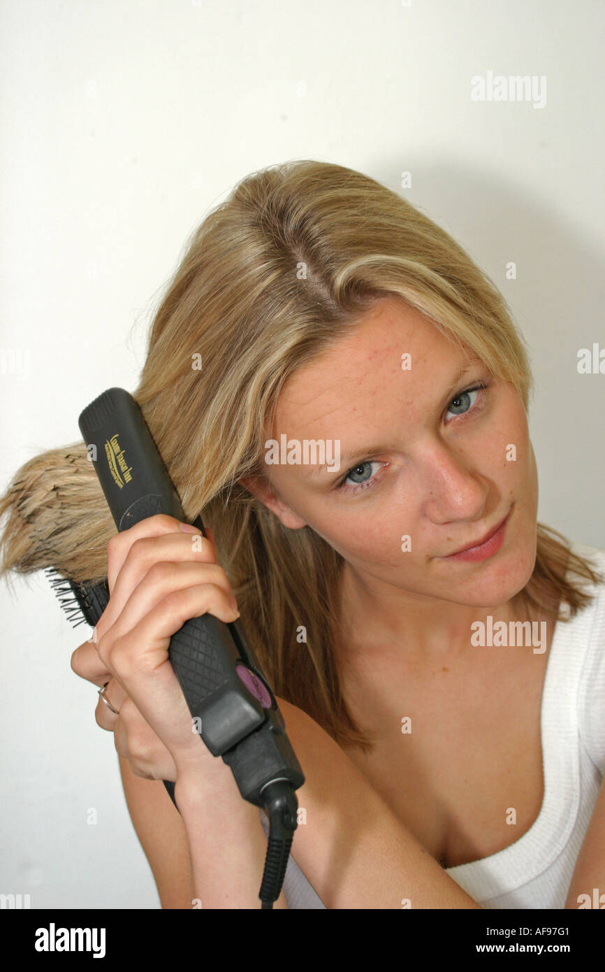 A Stock Photograph of a Teenage Girl Straightening her Hair Before Going Out Stock Photo