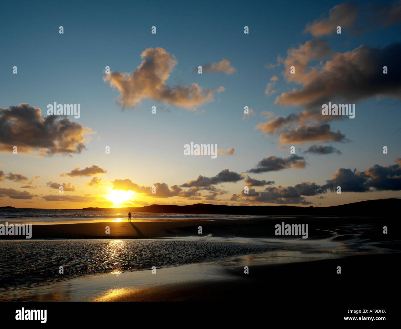 solitary figure on beach at sunset Stock Photo