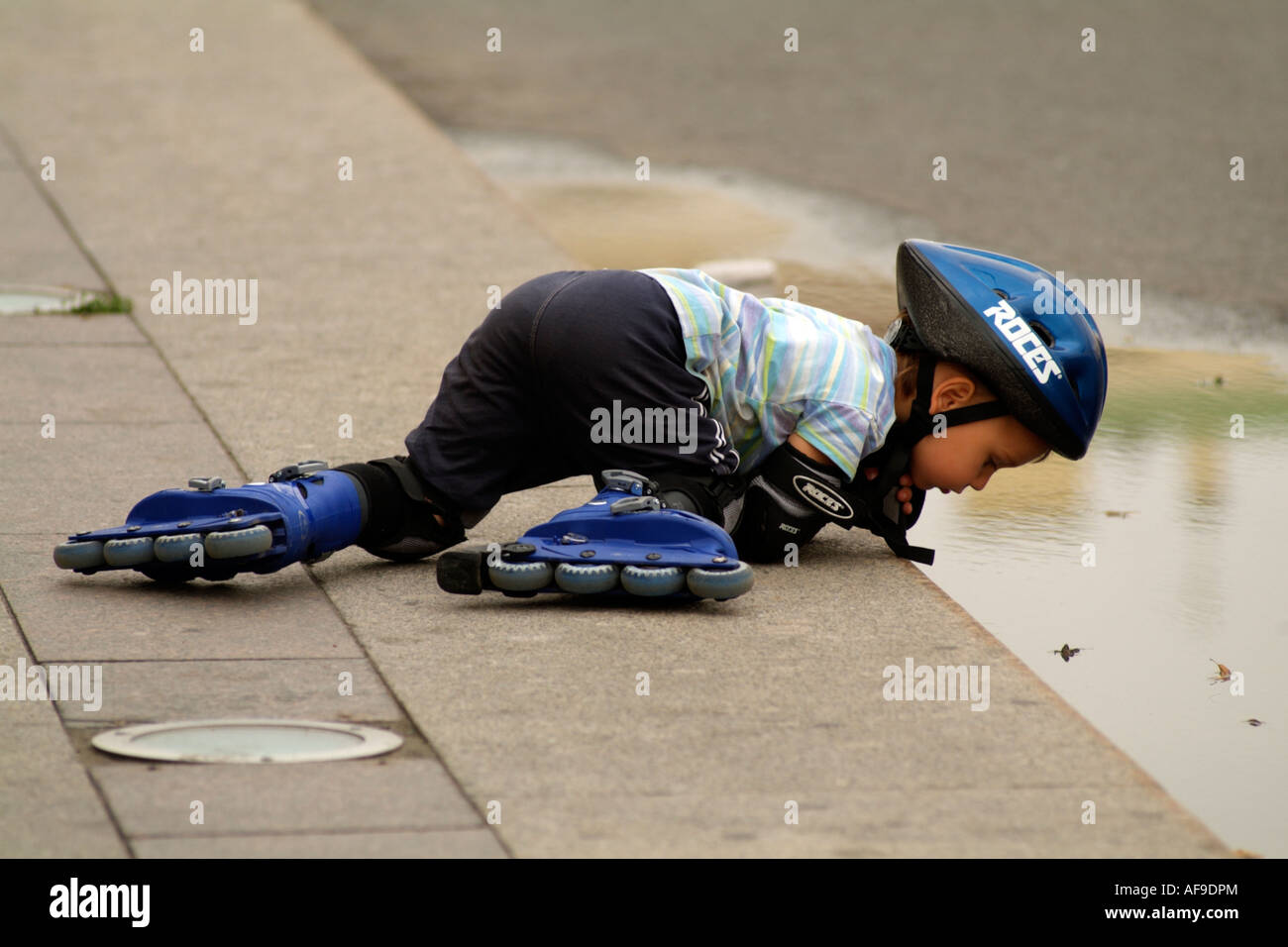 Child wearing rollerblades and safety helmet and elbow equipment Looks