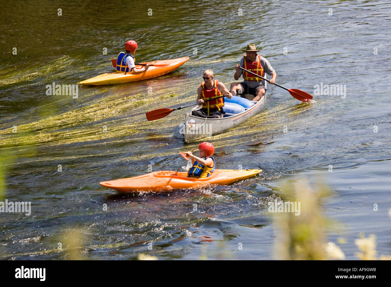 Canoeists in kayaks and Canadian canoes paddling down River Wye Lower