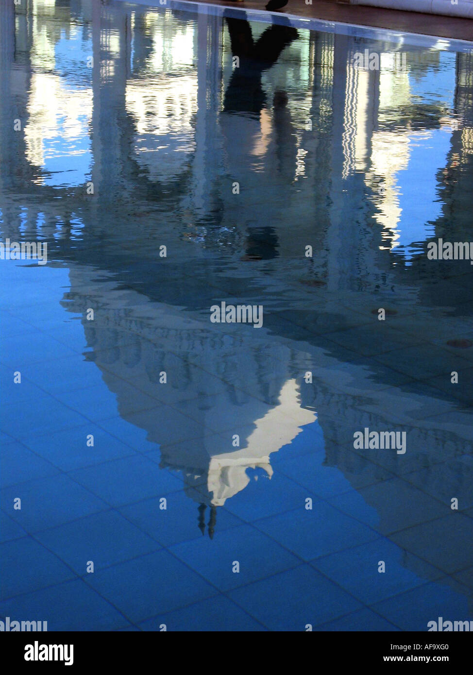 A waiter is reflected in the rooftop pool at the Udai Kothi Hotel, Udaipur. Stock Photo