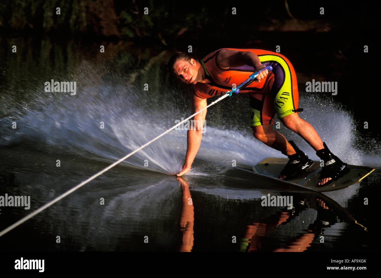 Water-skier in action dragging his hand on the water surface while executing a turn South Africa Stock Photo