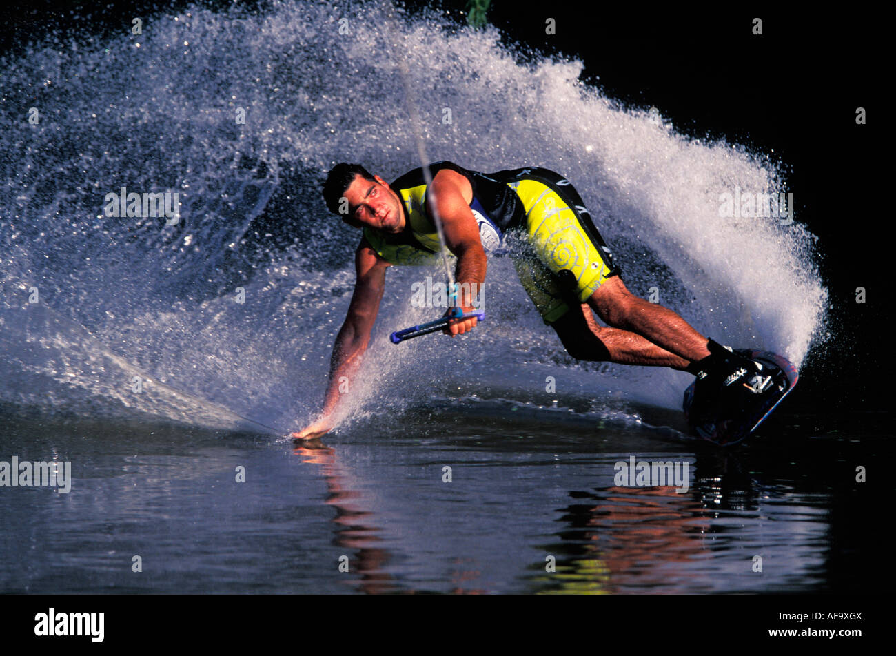 Water-skier on a wakeboard makes a sharp turn dragging his hand on the water surface South Africa Stock Photo