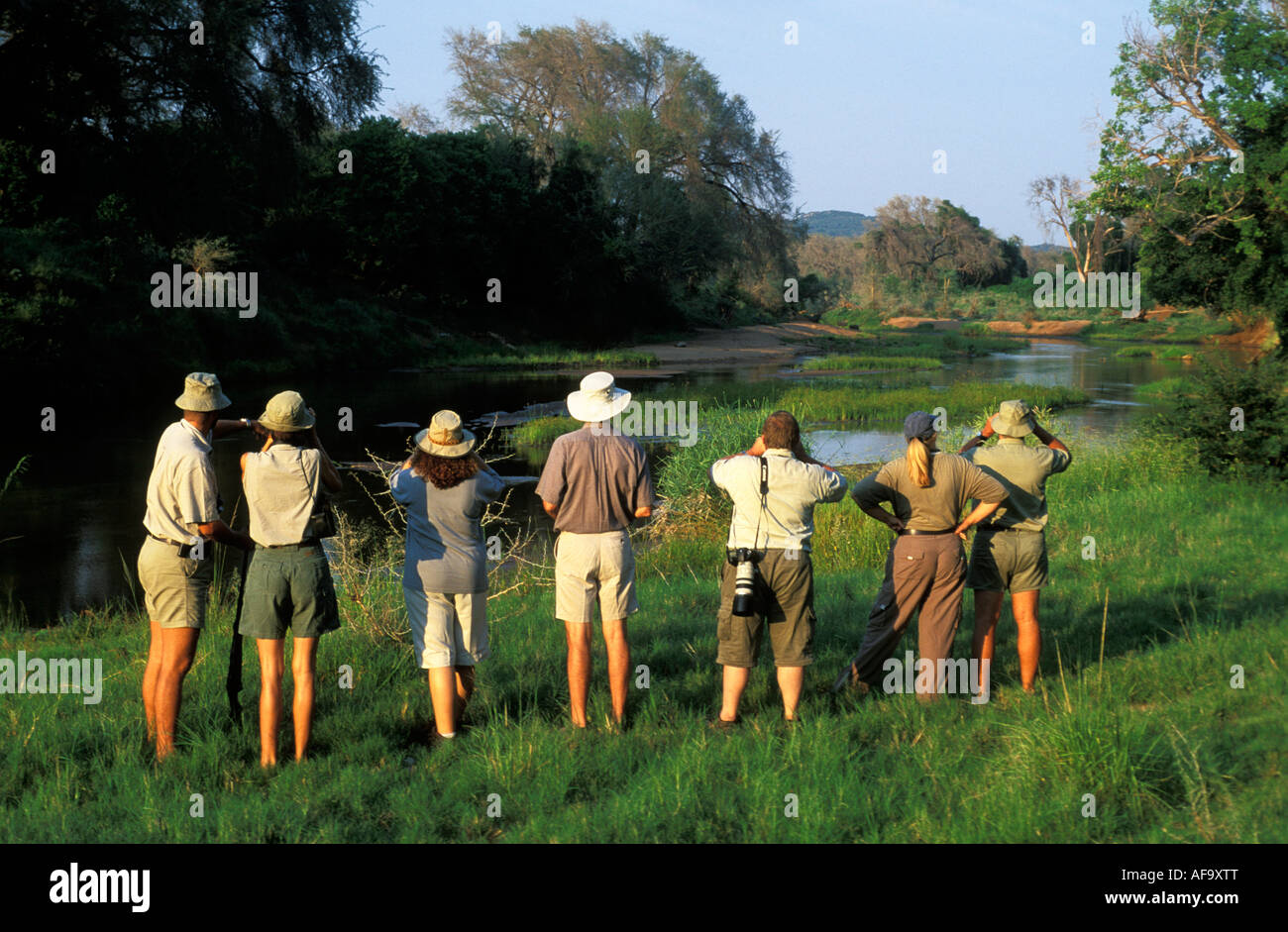 A group of hikers with an armed game guard while on a wilderness hike with Ecotraining on the banks of the Luvuvhu River. Stock Photo